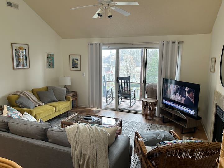 غرفة معيشة ذات مفهوم مفتوح بشاشات في الشرفة.