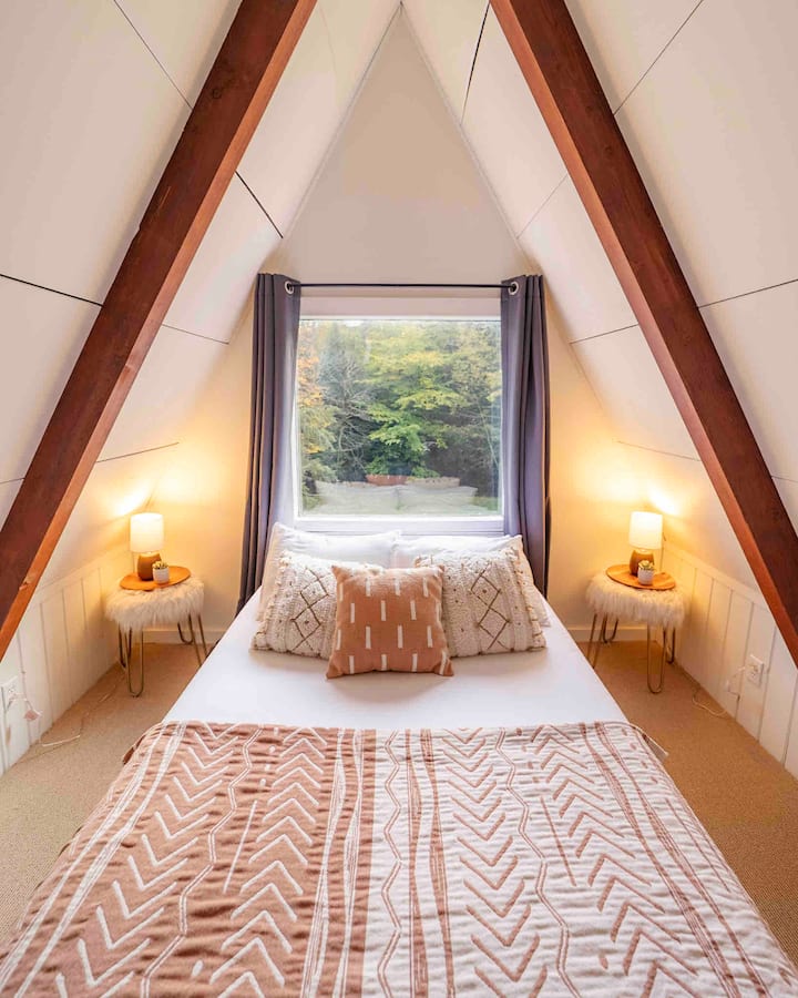 Third floor bedroom with a full bed and view of the backyard overlooking forest & stream. 

Photo @dirtandglass