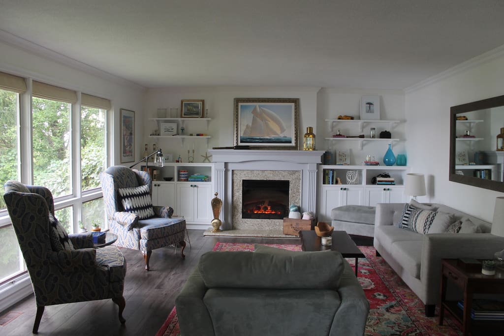 Main floor: Bright and comfortable open concept living room with picture windows looking out to the back gardens and water
