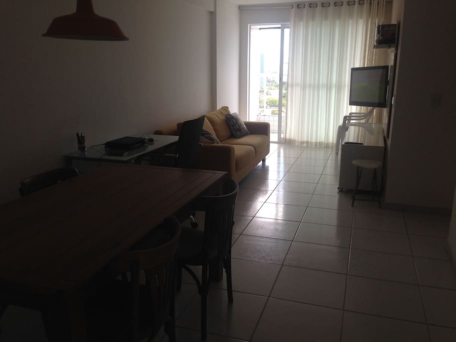 Sala com ambiente de jantar, trabalho, e TV