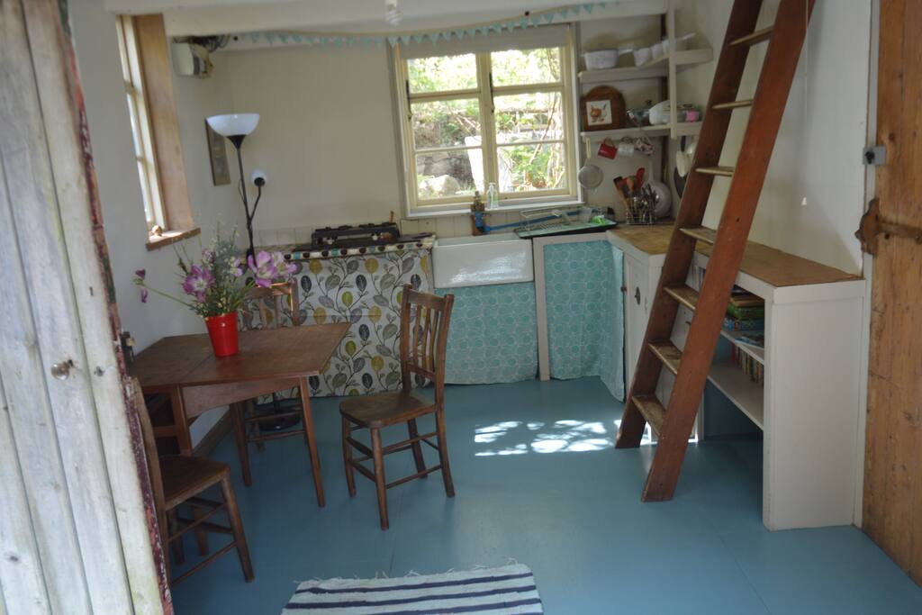 Kitchen - table, chairs, sink and a lot more! (+ Wooden stairs to loft-bedroom.)