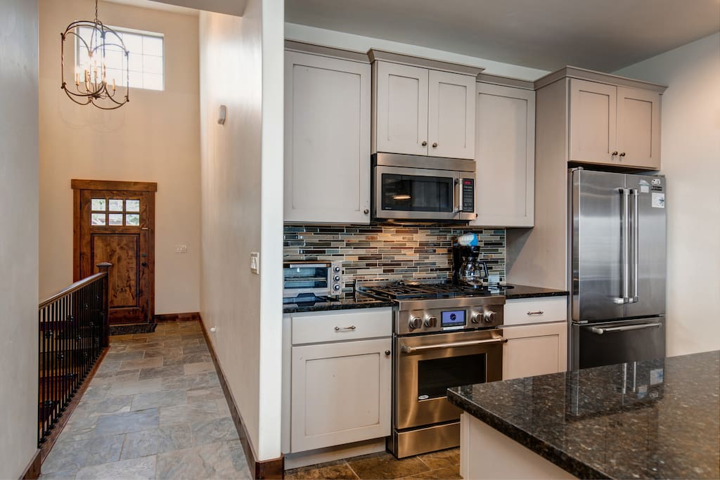 Main entry way straight ahead and fully equipped kitchen to the left