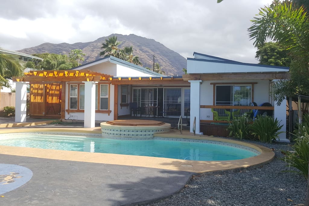 View from across the pool showing the outdoor seating areas and Makaha mountains in the backround