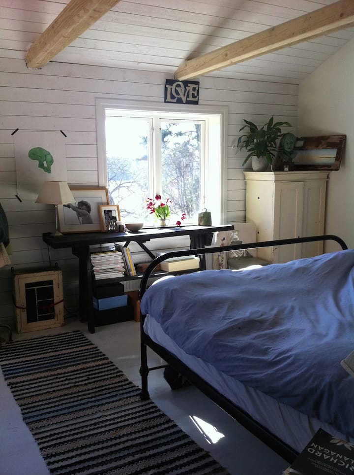 ห้องนอนใหญ่ (ชั้นล่าง) พร้อมเตียงขนาดคิงไซส์และประตูระเบียงออกไปยังดาดฟ้า 