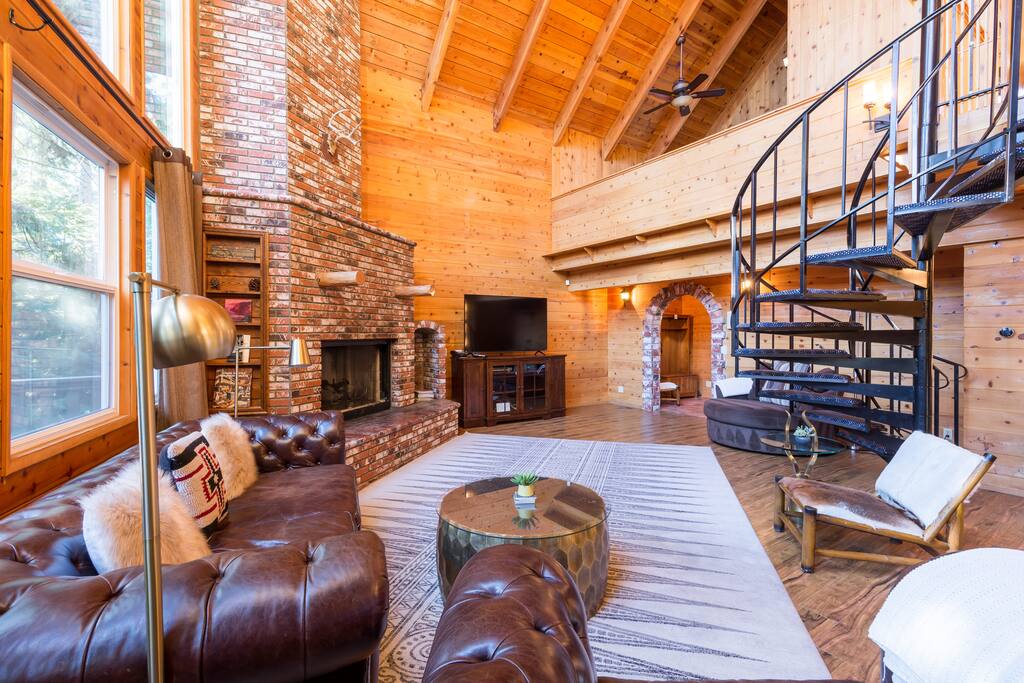 Main level living room with spiral staircase up to loft game room & guest room