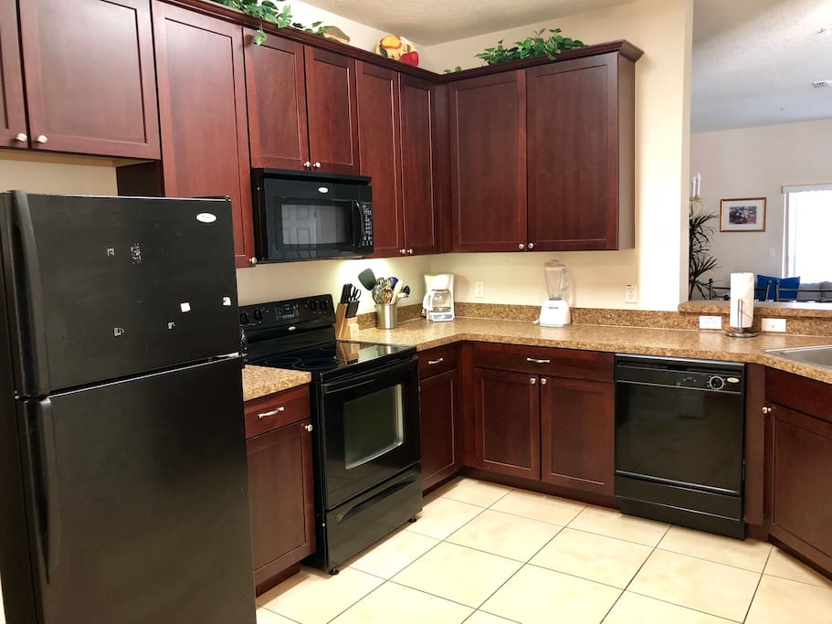Fully furnished kitchen with microwave, stove, refrigerator, and supplies!