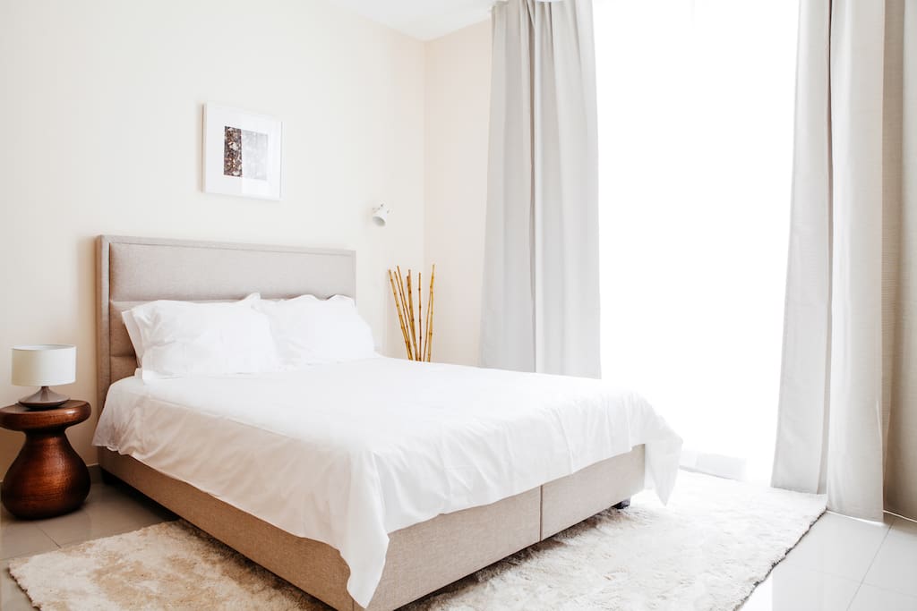 Natural light and beige tones dress the bedroom