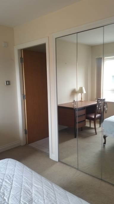 Dore to shower room. Desk reflected in built-in wardrobe mirror doors.