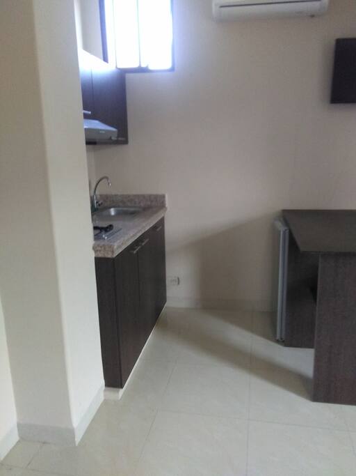 Cocina con estufa con campana y lavaplatos, mini nevera