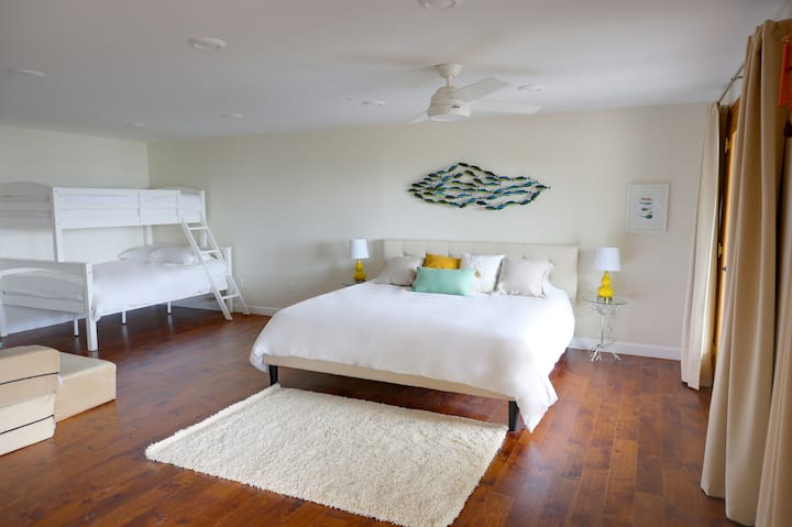 Hummingbird Bedroom - King Bed + Full and Single Bunk Bed + Queen Sofabed. Two sets of double doors with views of the lake, lead out onto the main deck.