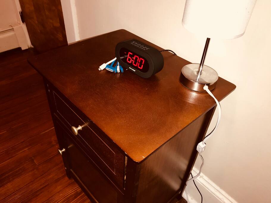 room has a lamp, alarm clock, and extra charging cables