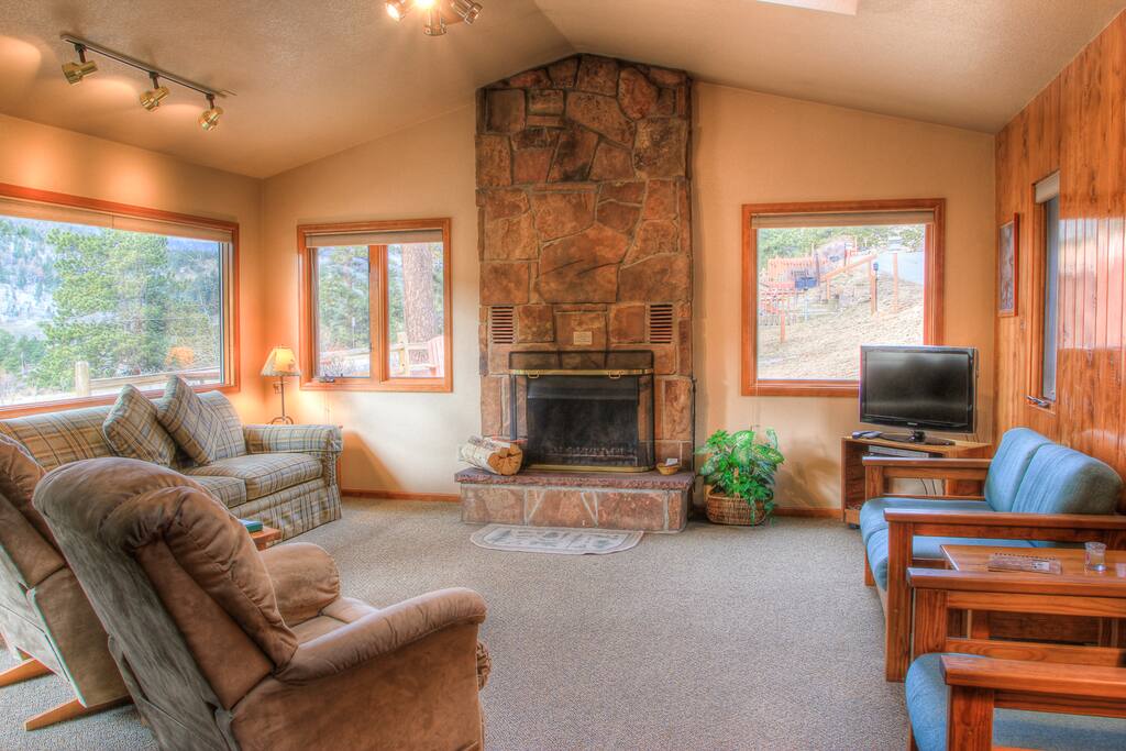 Spacious living room, with stone, wood burning fireplace.