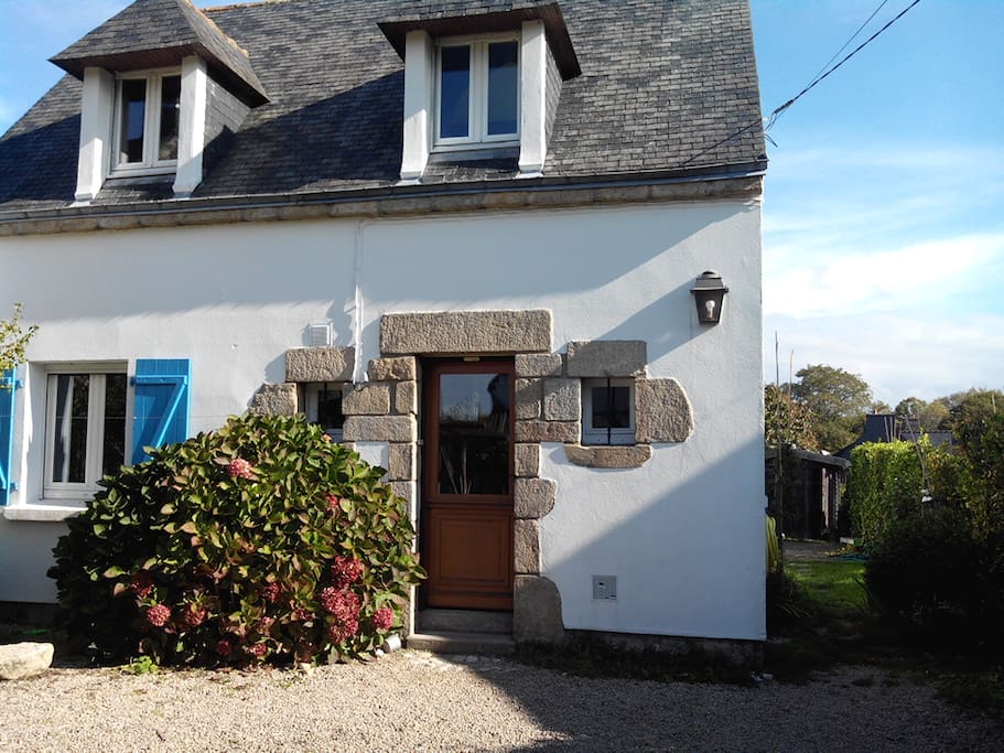 Accès jardin avec pelouse et terrasse agréable pour déjeuner, située derrière la maison.