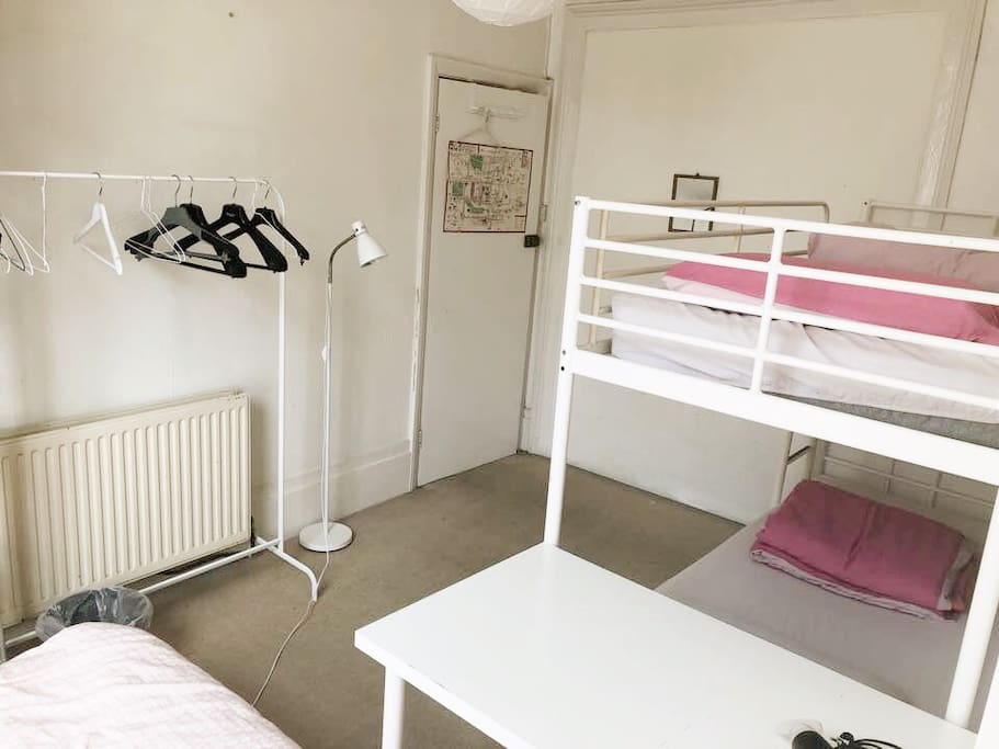 A table, a clothing rack, a lamp stand.