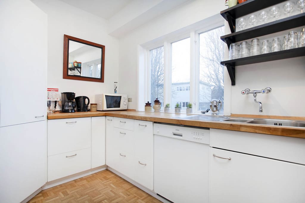 There is a dishwasher, coffee maker, microwave and an electric kettle.