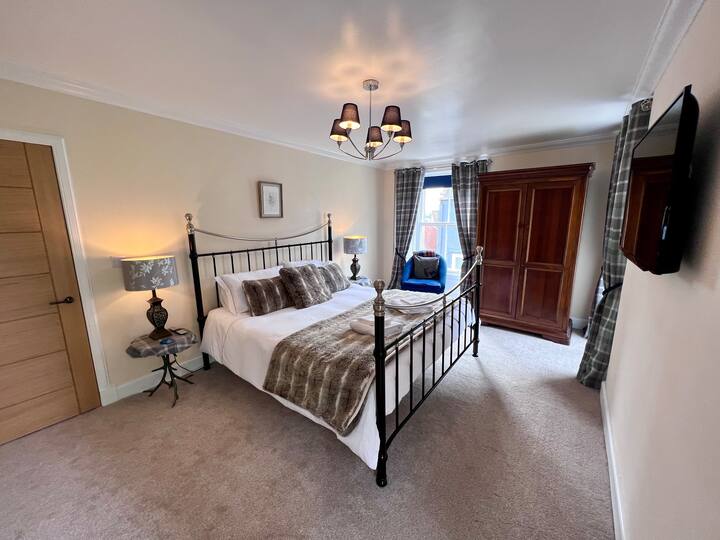 Master bedroom. Surrounding windows with view of Coldstream high street. Super king size bed.