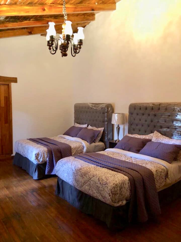 Recamara con dos camas matrimoniales cuenta con amplio vestidor y baño, con vista a la naturaleza