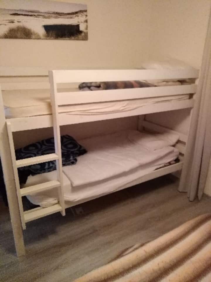 חדר עם מיטה זוגית אחת ומיטת קומתיים אחת 