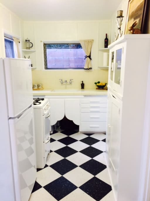 Farm house style kitchen with vintage stove. Fully equipped with cookware, dishes, coffee-maker, and essential spices. Guests are welcome to enjoy gifts of the garden--lemons, limes, figs, kumquats, leafy greens.