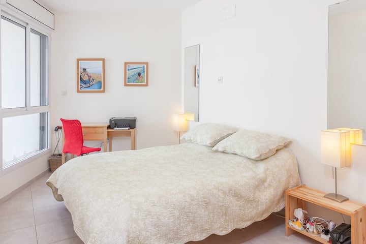 Dormitorio principal con un baño completo con vistas al mar desde la cama de tamaño completo.