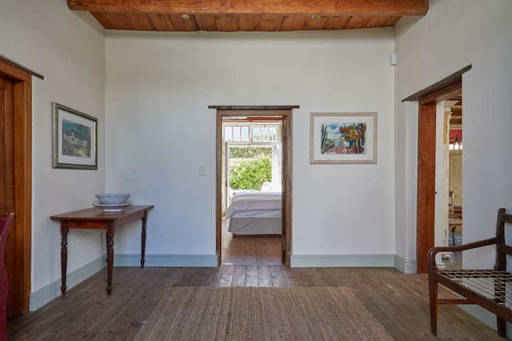 Vstupná hala s toaletou pre hostí naľavo, spálňa pred domom a kuchyňa a obývacie priestory vpravo