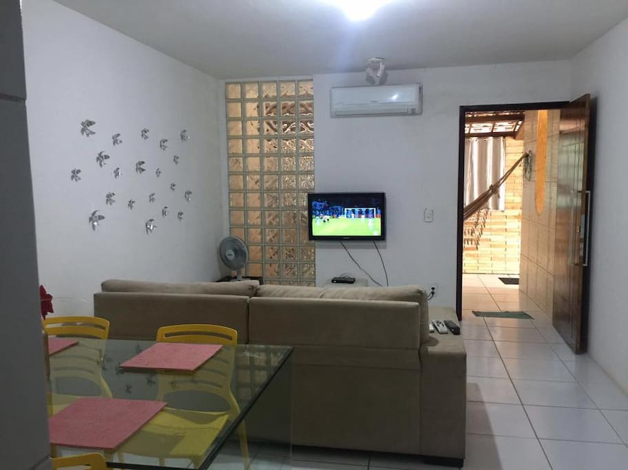 Sala, com sofá, televisão (com sky), mesa com 4 lugares.