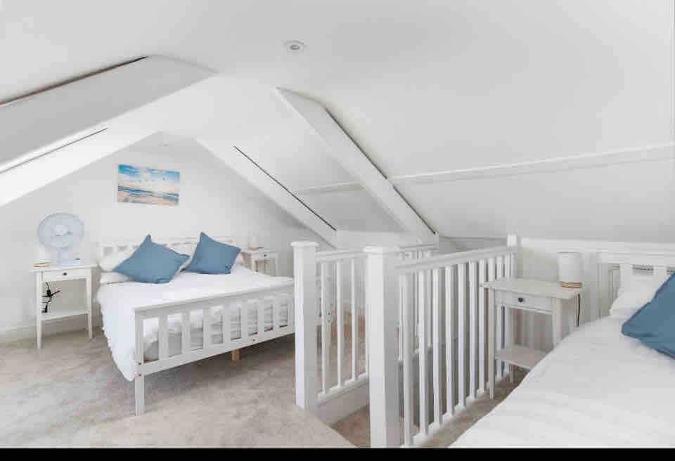 带双人床和一张单人床的阁楼卧室