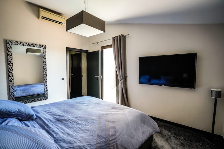 Dhomë gjumi kryesore me ajër të kondicionuar me krevat dopio "queen" dhe ekran televizori