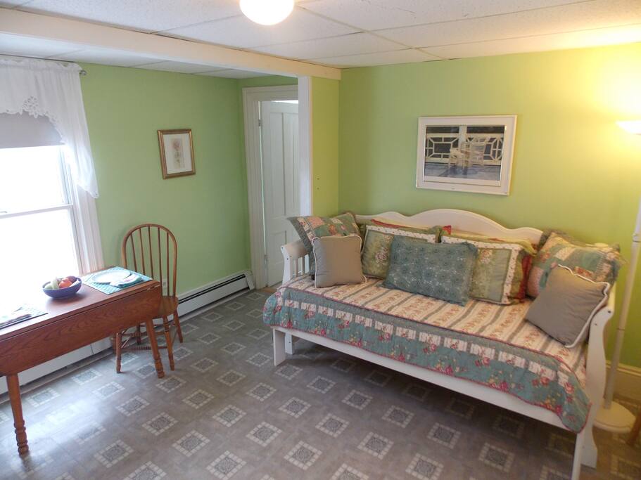 Combined living space and kitchen with twin sized daybed for third person
