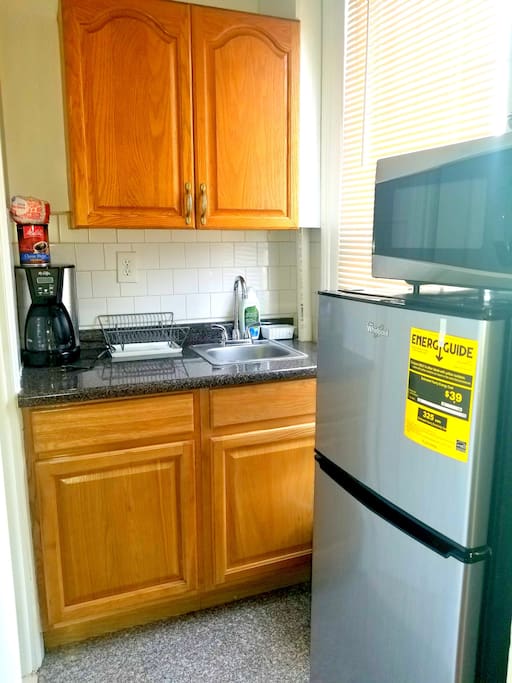 Kitchenette with Refrigerator, Microwave and Coffee Machine.