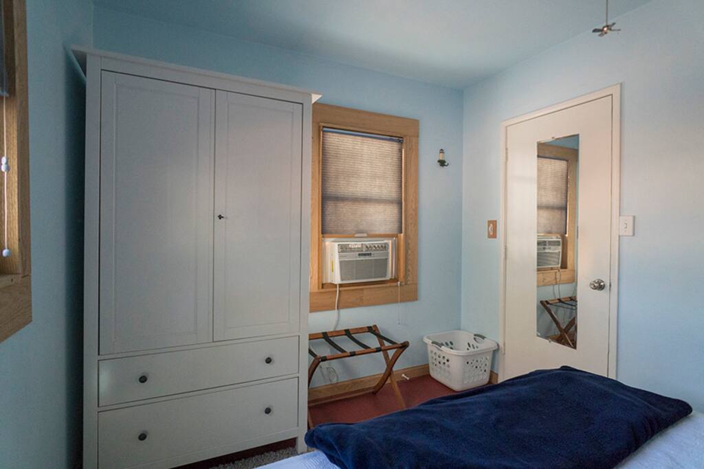 The opposite end of the bedroom with a wardrobe for your clothing, laundry basket and luggage rack.