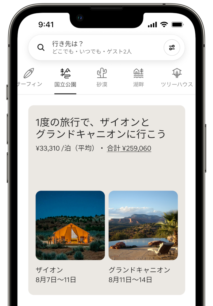 携帯電話の画面に「国立公園」カテゴリの「宿泊先の分割」が表示されています。画面には「1度の旅行で、ザイオンとグランドキャニオンに行こう」と表示され、宿泊料金も提示されています。下には、写真が2枚横に並んでいます。ザイオンの写真には、暗い空の下に光る広々としたテントが写っています。グランドキャニオンの写真には、山の景色が広がる屋外プールが写っています。それぞれの写真に日程が記されており、ゲストはザイオンに4日間滞在し、その後グランドキャニオンに3日間滞在することがわかります。