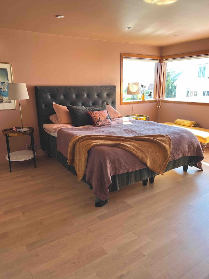 Utalala kama mtoto katika chumba hiki cha kulala chenye nafasi kubwa. Kitanda kipya kabisa cha ukubwa wa mfalme, chagua upande wako - nusu ya kitanda ni laini wakati nusu nyingine ni thabiti. Furahia kahawa yako ya asubuhi kwenye roshani inayoangalia fjord na safu ya milima. 