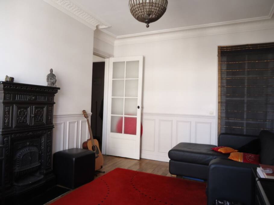 Living room with a convertible sofa and a piano (foreground). Fireplace not usable