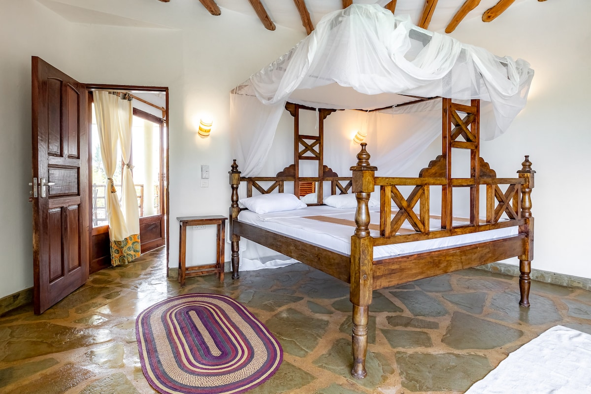 Suite principal (planta superior): dormitorio con aire acondicionado y una cama tamaño king con mosquiteros.