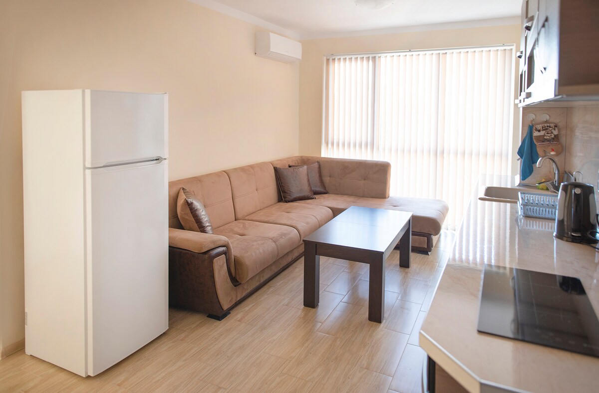 Светла всекидневна и напълно оборудвана кухня 