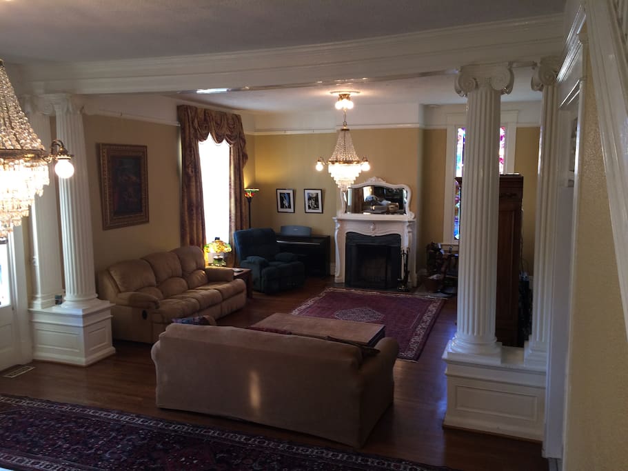 Family room with 55" HD TV, stained glass window, working fireplace, antique chandeliers and queen sofa bed.