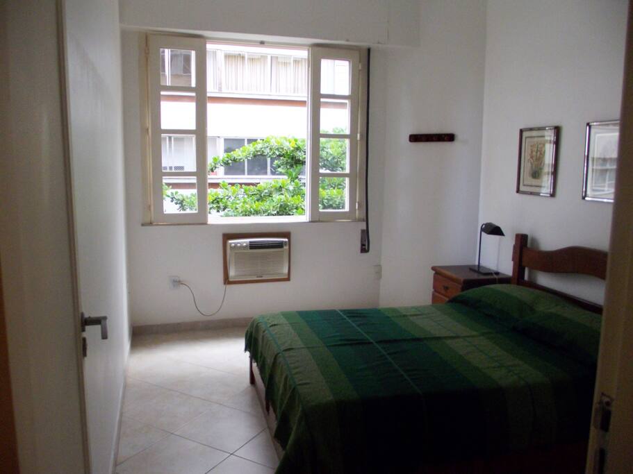 Main bedroom: double bed, air conditioning and ceiling fan. Pleasant good/fresh tree's view. Integrated curtain that grants perfect blackout for sleeping.