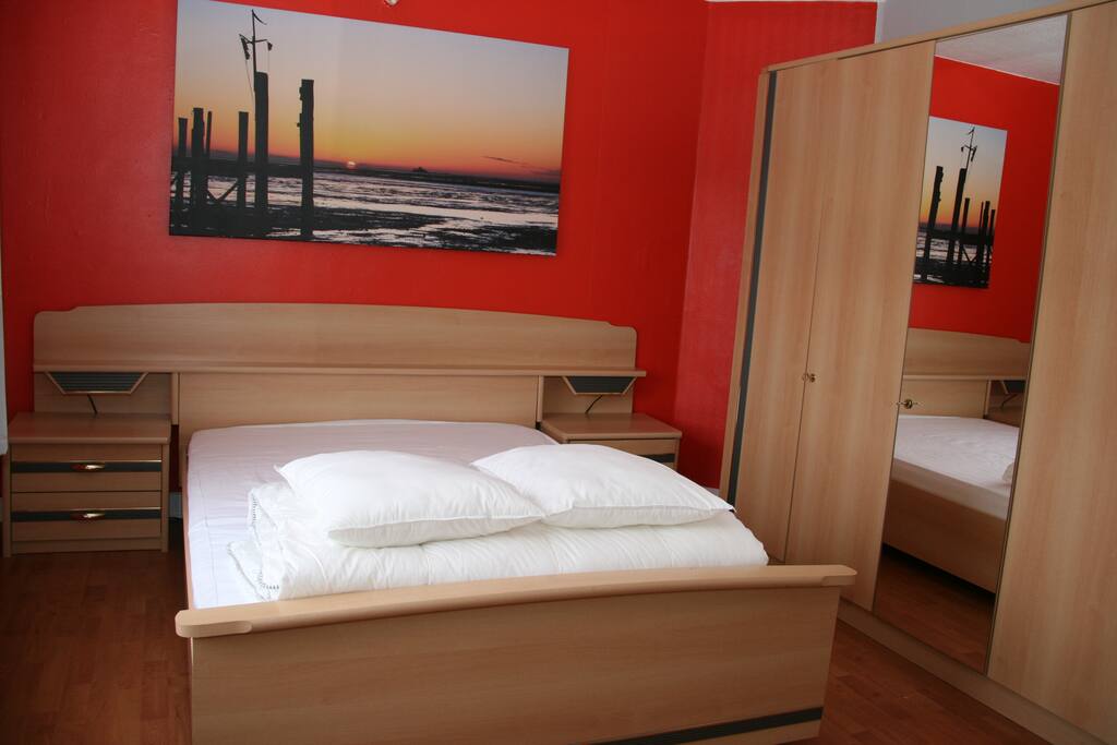Notre chambre rouge avec un lit double.