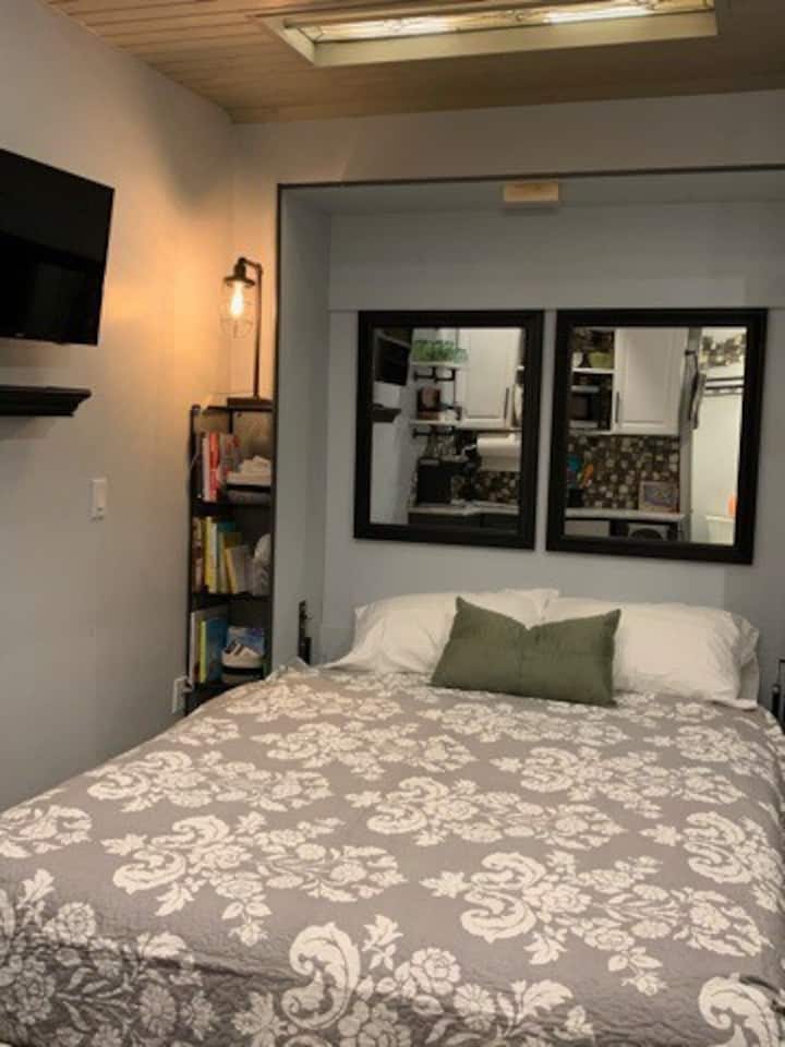 Cama murphy tamaño queen que se levanta fácilmente en protocolos cargados de muelles contrasentados. Las sábanas son exuberantes y las ventanas de vidrio con plomo iluminadas están en el techo.