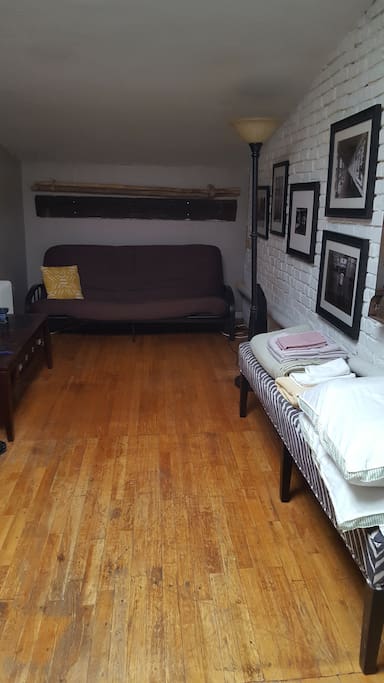 Futon lays out to comfortably sleep 2, ample clean bedding provided