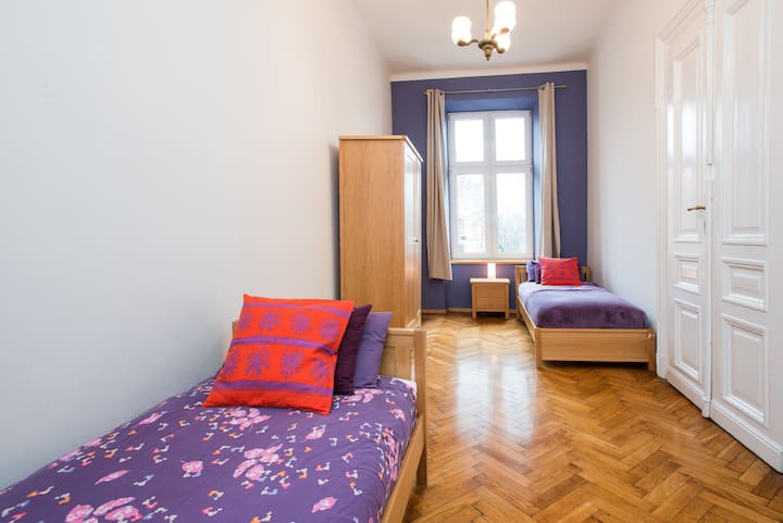 一间大房间，每间配备两张单人床，配备一张床头柜和一个衣柜