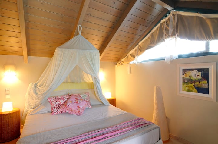 dormitorio principal loft con cama tamaño queen con baño privado y balcón.