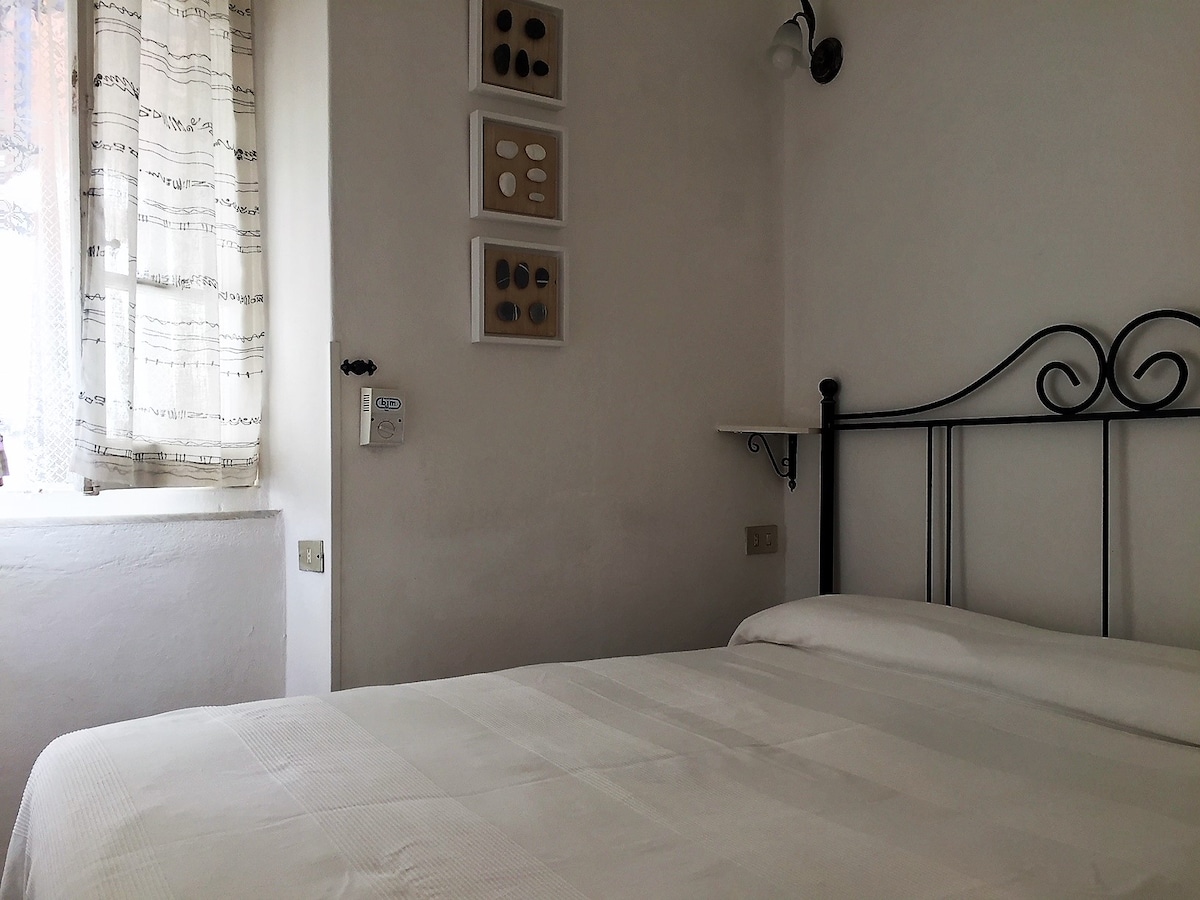 Spavaća soba s ventilatorom na stropu.