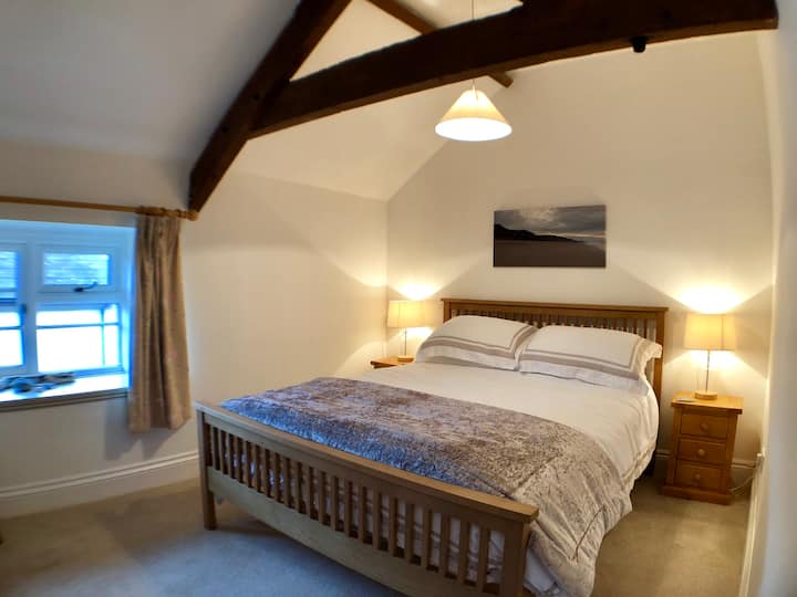 חדר שינה שני עם מיטת קינג סיז וקורות חשופות