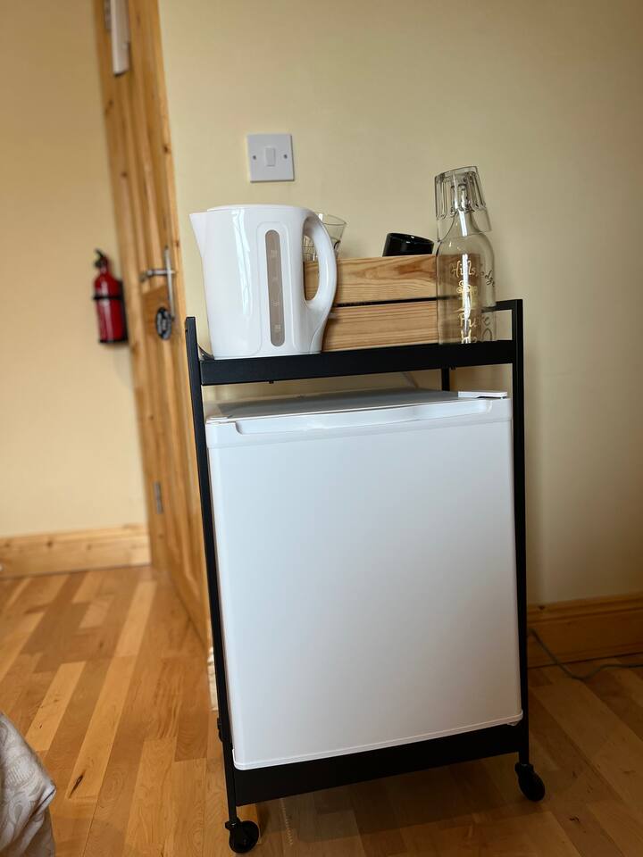 Your mini fridge and kettle. Fridge is stocked with fresh orange juice, milk, filtered water , and locally produced fresh scones and croissants , for your breakfast. Also a choice of cereals.