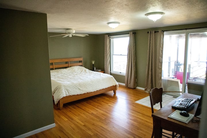 ห้องนอนชั้นแรกพร้อมเตียงคิงไซส์และทางเข้าลานบ้าน