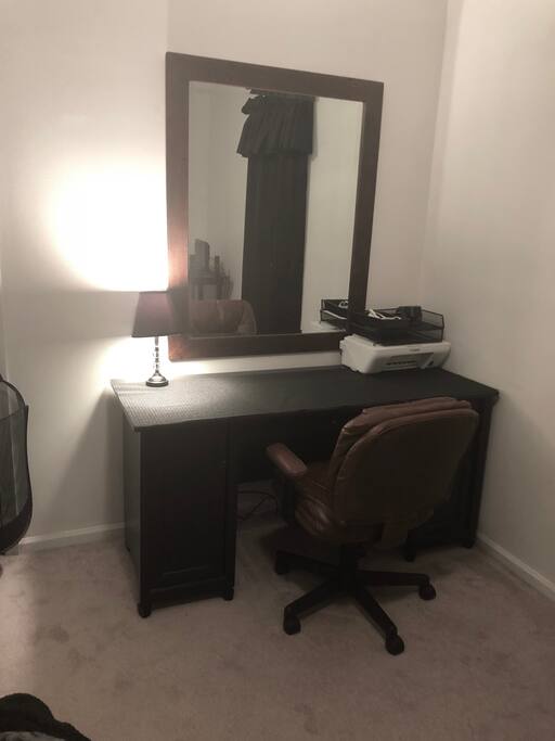 Large desk with comfortable office chair, lamp and extra electrical cords for charging your electronics. Large mirror and printer in room with basic office supplies if needed.