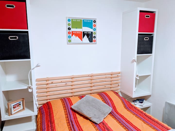 سرير 140 سم في الغرفة. رف حائط على كل جانب من السرير وطاولتين بجانب السرير على العجلات. مصباح السقف ومصباحين بجانب السرير.