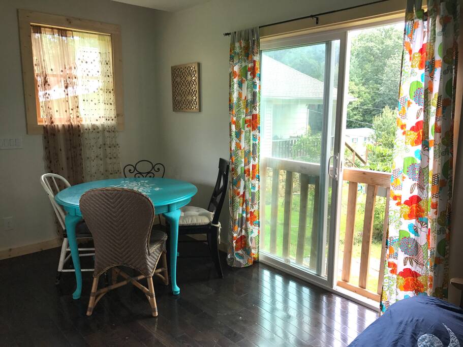 The large windows and natural light create a cozy and bright environment. The vintage table is round and perfect for conversations.